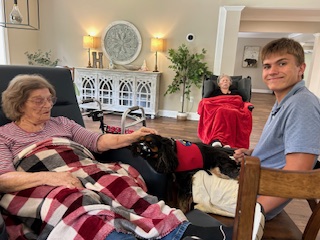 Will and service dog visiting with elderly residents